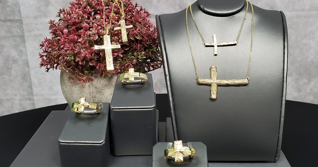 Display of gold cross necklaces and rings from the OG Christian Collection